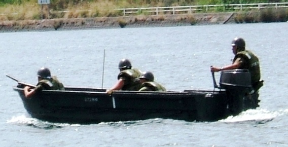 写真０６０８２３－１：ボートに乗る４人の自衛隊員。