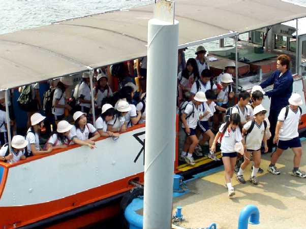 写真ｂ１９：落合下渡船場の渡し舟で通学する小学生たち。
