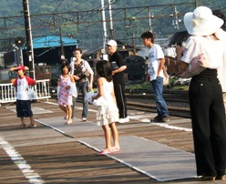 写真６−２：新金谷駅で停車中のＳＬに群がる子供たち。